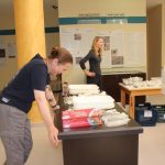 People setting up items for display cases