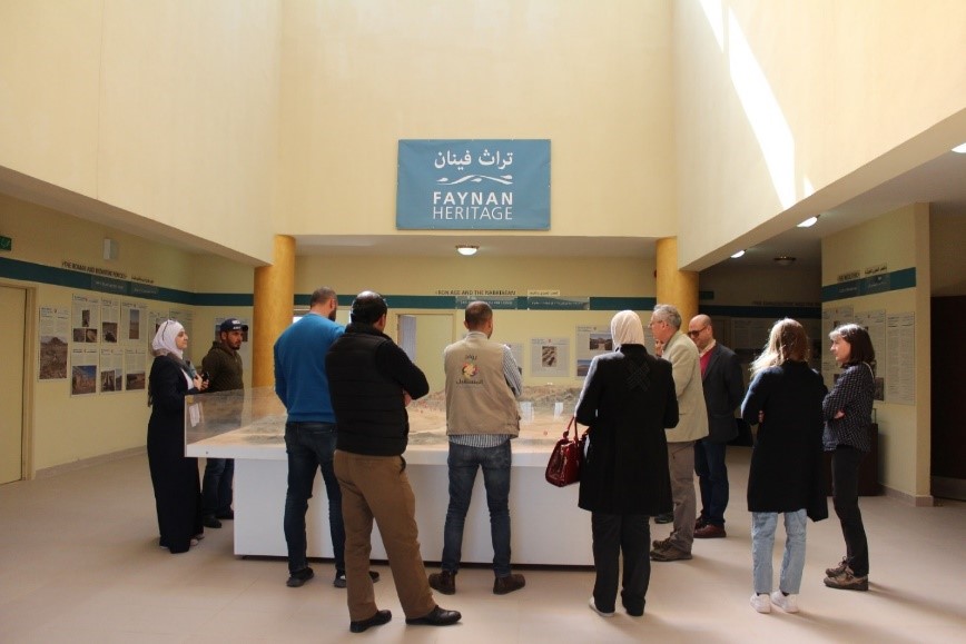 Group of people standing around display case in museum